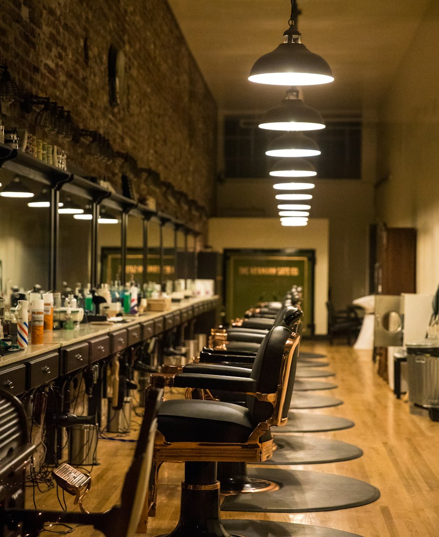 Interior de la barbería con la fila de sillones clásicos y lámparas colgantes